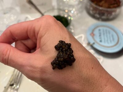 A dollop of caviar on the back of a person’s hand