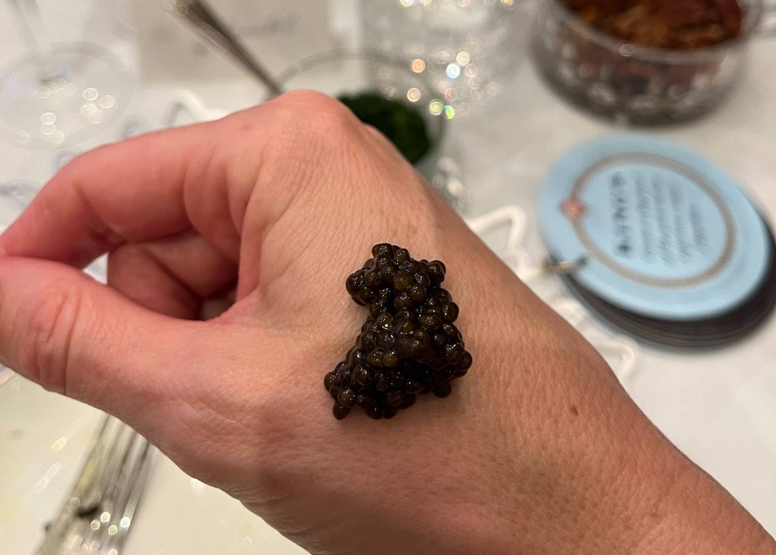 A dollop of caviar on the back of a person’s hand