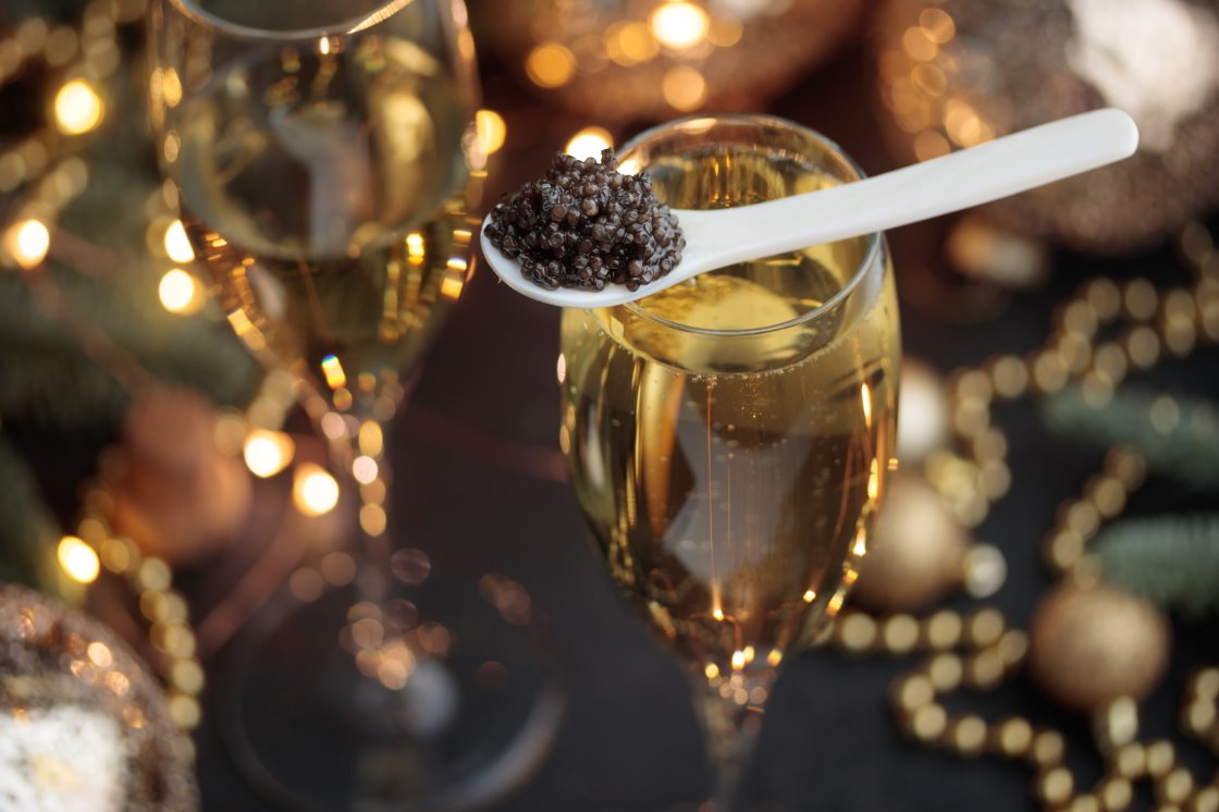 A mother-of-pearl spoon of caviar on a Champagne flute
